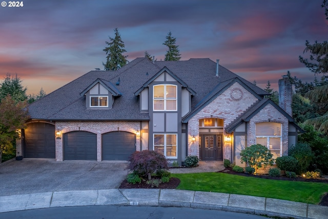 view of front of property with a garage and a lawn