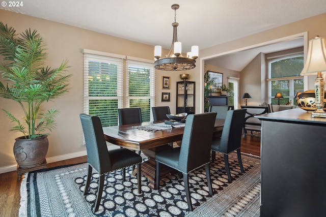 dining area with vaulted ceiling, a healthy amount of sunlight, and dark hardwood / wood-style flooring