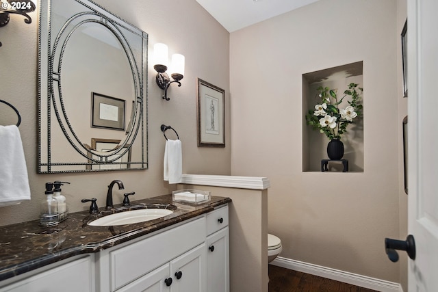 bathroom with vanity, hardwood / wood-style flooring, and toilet