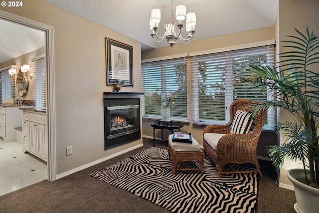 sitting room featuring an inviting chandelier, light carpet, and a textured ceiling