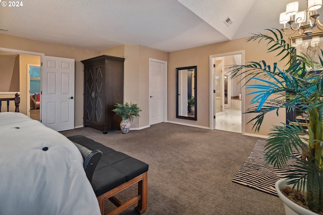 carpeted bedroom featuring connected bathroom, a chandelier, and a textured ceiling