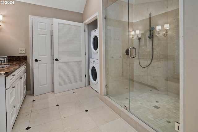 bathroom featuring vanity, stacked washer / drying machine, and walk in shower