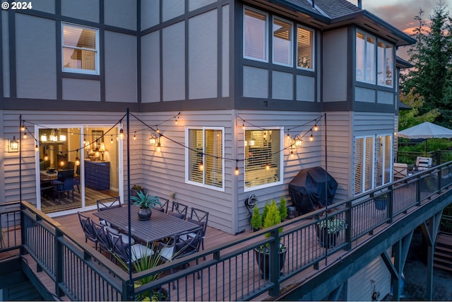 back house at dusk featuring a deck