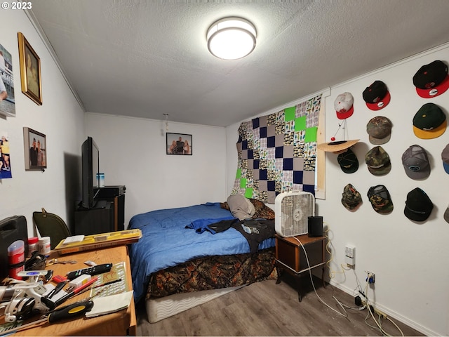 bedroom featuring wood-type flooring and a textured ceiling