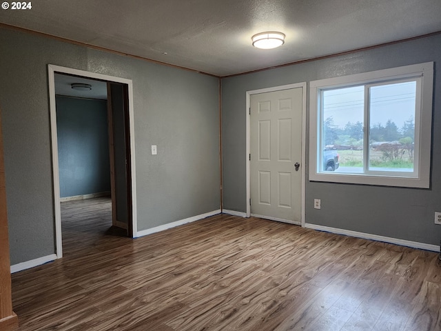 spare room featuring wood-type flooring and a textured ceiling