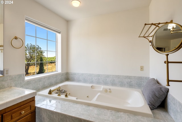 bathroom with tiled tub and vanity