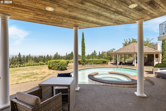 view of pool with an in ground hot tub and a gazebo