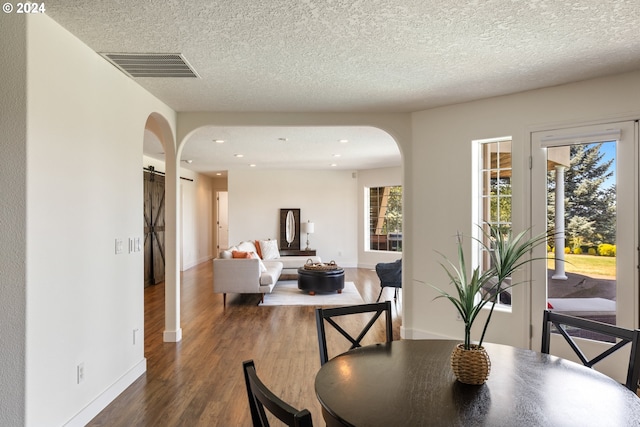 dining area featuring a textured ceiling and dark hardwood / wood-style flooring