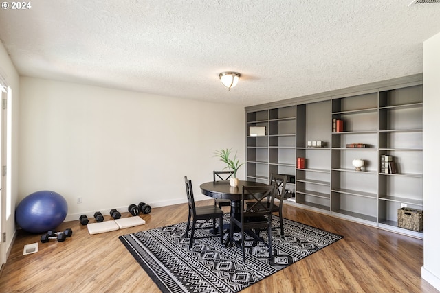 dining area featuring a textured ceiling, hardwood / wood-style floors, and built in features