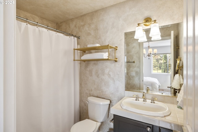 bathroom featuring vanity, a chandelier, and toilet