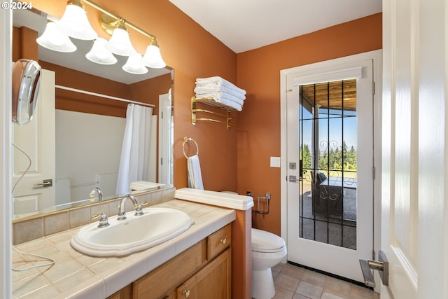 bathroom featuring toilet, vanity, tile patterned floors, and a shower with curtain