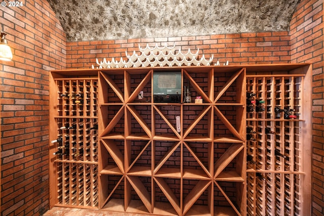 wine area featuring brick wall