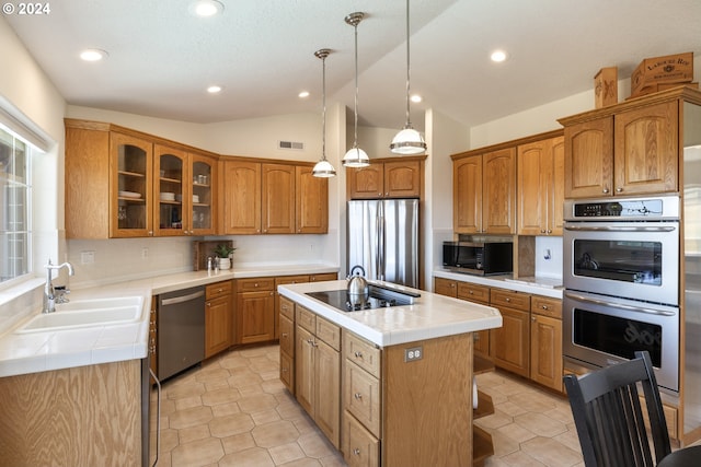 kitchen featuring stainless steel appliances, decorative backsplash, lofted ceiling, a kitchen island with sink, and sink