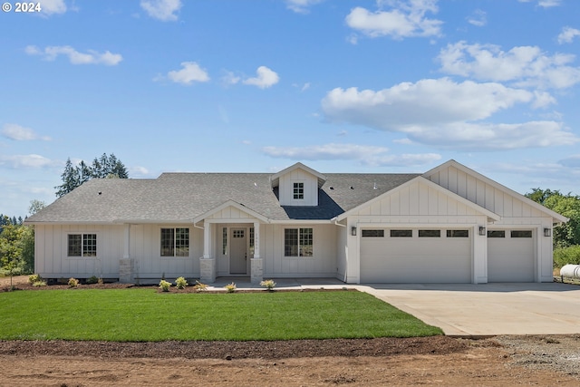 view of front of property with covered porch, a garage, and a front lawn