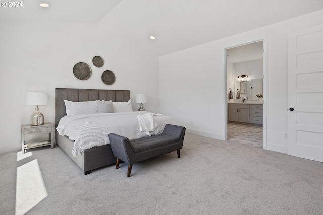 bedroom with light colored carpet and connected bathroom