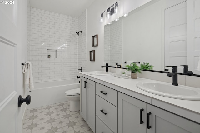 full bathroom featuring vanity, tiled shower / bath combo, and toilet