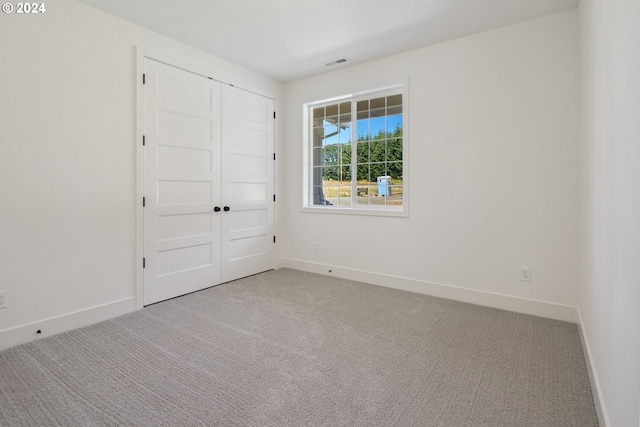 unfurnished bedroom with carpet floors and a closet