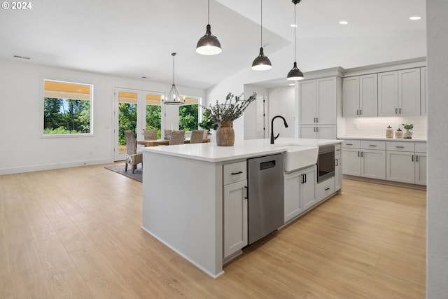 kitchen featuring pendant lighting, dishwasher, an island with sink, tasteful backsplash, and light hardwood / wood-style floors