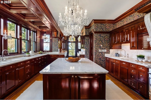 kitchen with wood-type flooring, a chandelier, a kitchen island, and sink