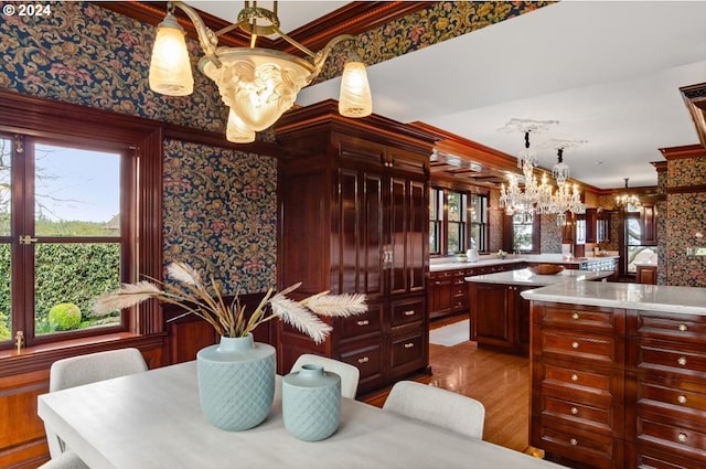 1816 SW Hawthorne Ter, Portland, OR 97201 - kitchen with a chandelier, crown molding, light countertops, dark brown cabinets, and wood finished floors