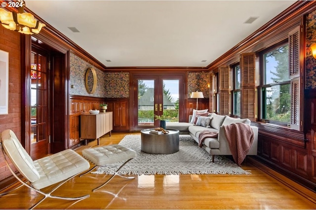 living room featuring french doors, light hardwood / wood-style floors, and crown molding