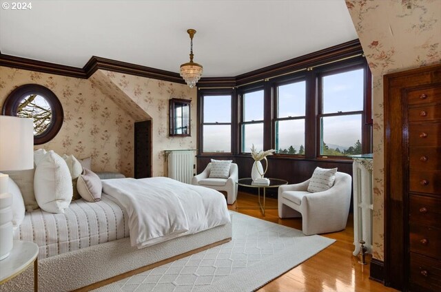 bedroom featuring light hardwood / wood-style flooring, crown molding, and multiple windows