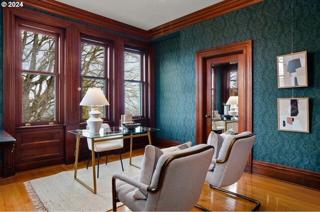 home office featuring ornamental molding, a wealth of natural light, and light hardwood / wood-style flooring