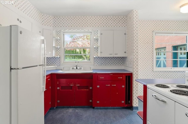 1816 SW Hawthorne Ter, Portland, OR 97201 - kitchen with white appliances, red cabinetry, a sink, light countertops, and wallpapered walls
