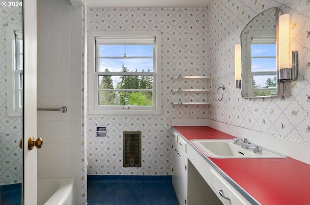 bathroom with a bath, heating unit, and vanity