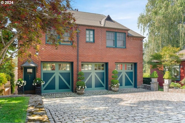 view of front facade featuring brick siding, decorative driveway, and an attached garage