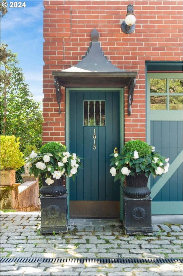 doorway to property with brick siding and board and batten siding