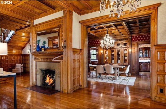 interior space with wood-type flooring, beam ceiling, wood ceiling, a notable chandelier, and wooden walls