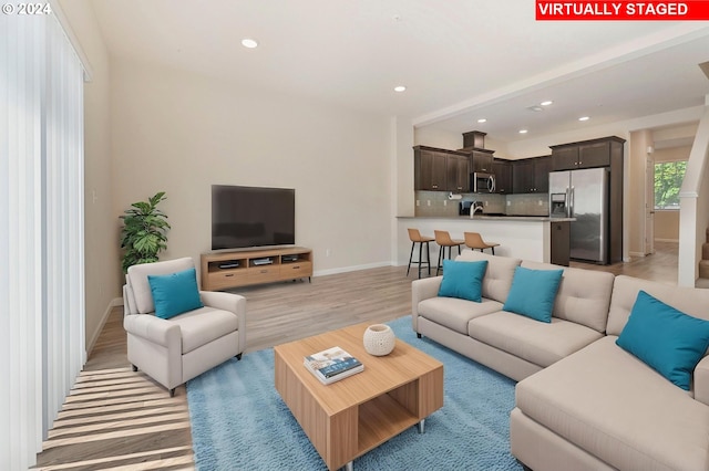 living room with light hardwood / wood-style flooring and sink