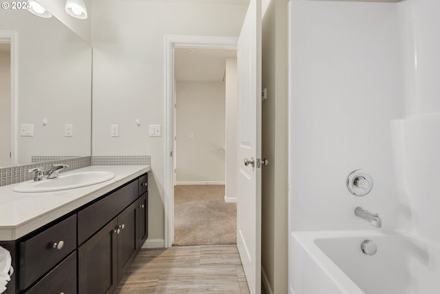 bathroom with vanity, baseboards, and bathtub / shower combination