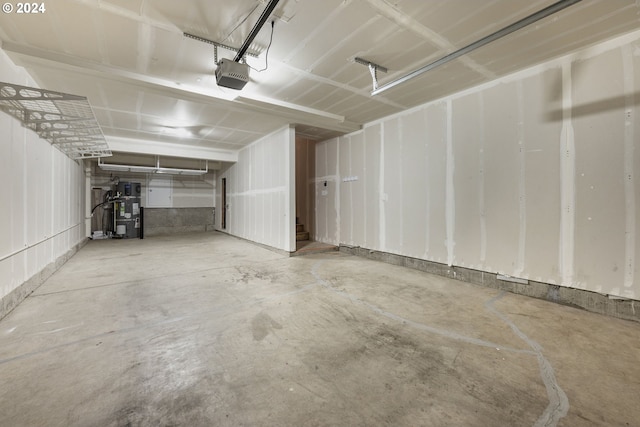 garage featuring heat pump water heater and a garage door opener