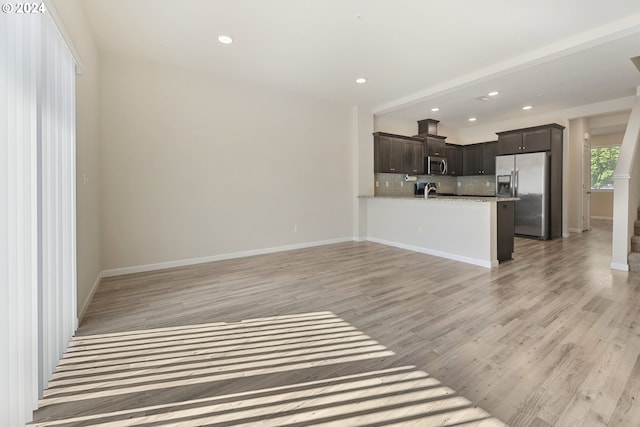 unfurnished living room with light hardwood / wood-style flooring and sink