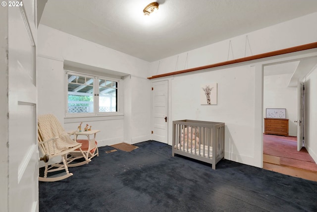 bedroom with dark carpet and a crib