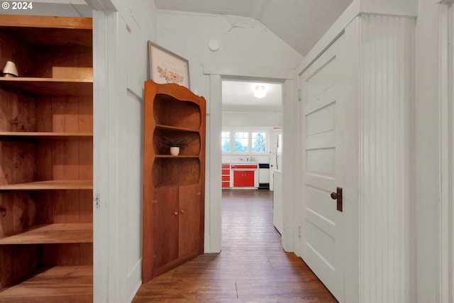 hallway with dark hardwood / wood-style floors and vaulted ceiling