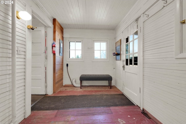 doorway to outside featuring hardwood / wood-style floors and wood walls