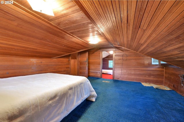 unfurnished bedroom with wood walls, wooden ceiling, lofted ceiling, and dark colored carpet