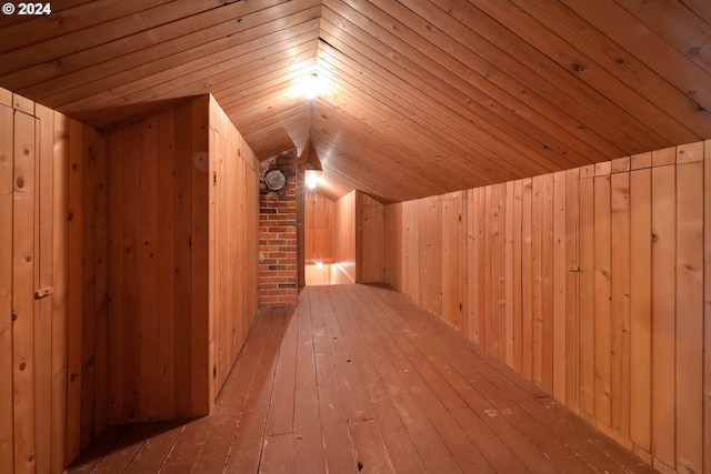 additional living space featuring light hardwood / wood-style flooring, vaulted ceiling, wood ceiling, and wood walls