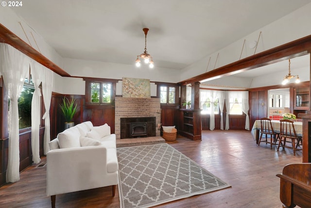 living room featuring wood-type flooring, a healthy amount of sunlight, and a notable chandelier