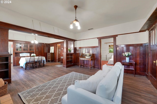 living room featuring dark wood-type flooring and an inviting chandelier