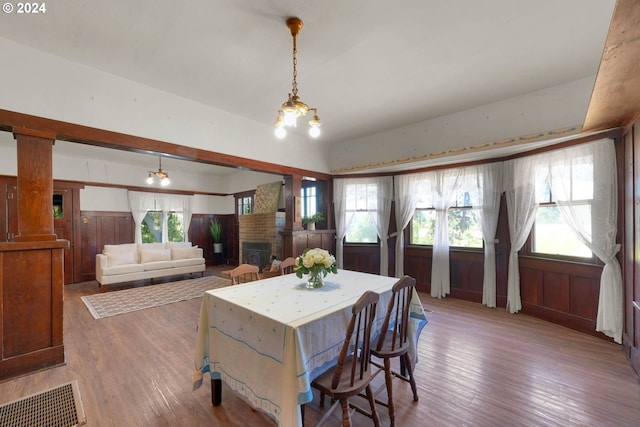 dining room featuring dark hardwood / wood-style floors, a healthy amount of sunlight, and an inviting chandelier