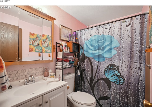 bathroom featuring a shower with curtain, vanity, and toilet