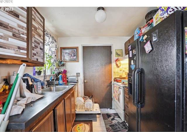 kitchen with black fridge with ice dispenser, electric stove, and sink