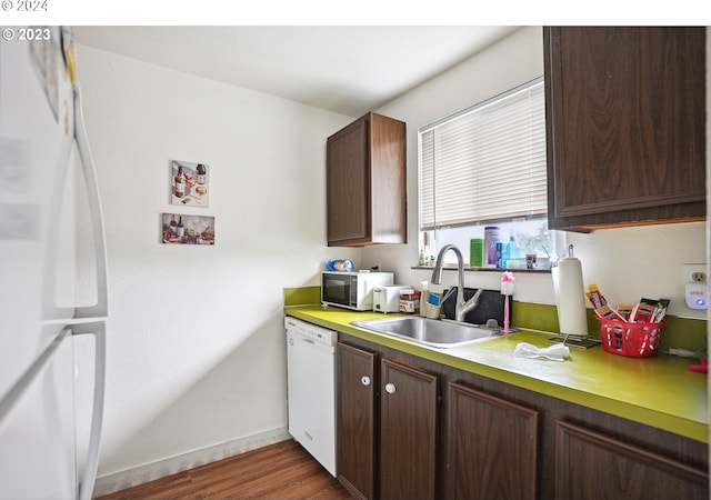 kitchen featuring dark hardwood / wood-style flooring, white appliances, sink, and dark brown cabinetry