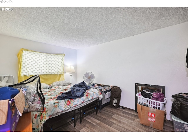 bedroom featuring hardwood / wood-style flooring and a textured ceiling