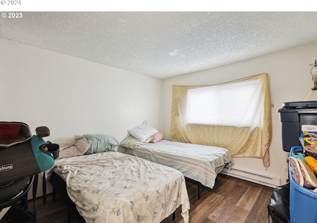 bedroom with a textured ceiling, dark hardwood / wood-style flooring, and baseboard heating