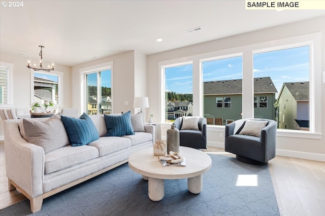 living room with plenty of natural light, a chandelier, and hardwood / wood-style flooring